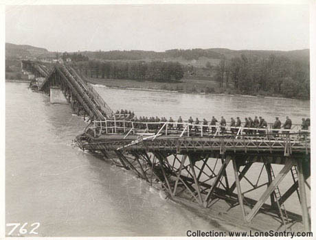 [German troops cross destroyed bridge to head into U.S. captivity in 1945]