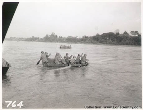 [River crossing - U.S. soldiers paddle across a river]