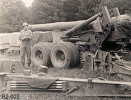 [S/Sgt. Tex Roberson with Howitzers of 995th FA Bn]