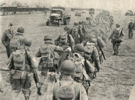 [53rd Troop Carrier Wing: GIs march alongside aircraft]