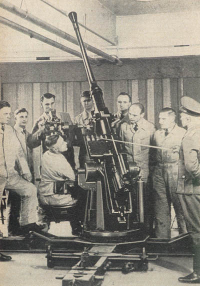[Figure 9. Demonstration class inspecting 3.7-cm (37-mm) AA/AT gun. (The German instructor is pointing to the feed mechanism.)]